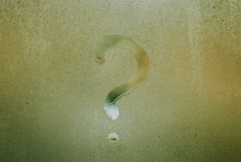 a dewy window with a question mark drawn in the condensation
